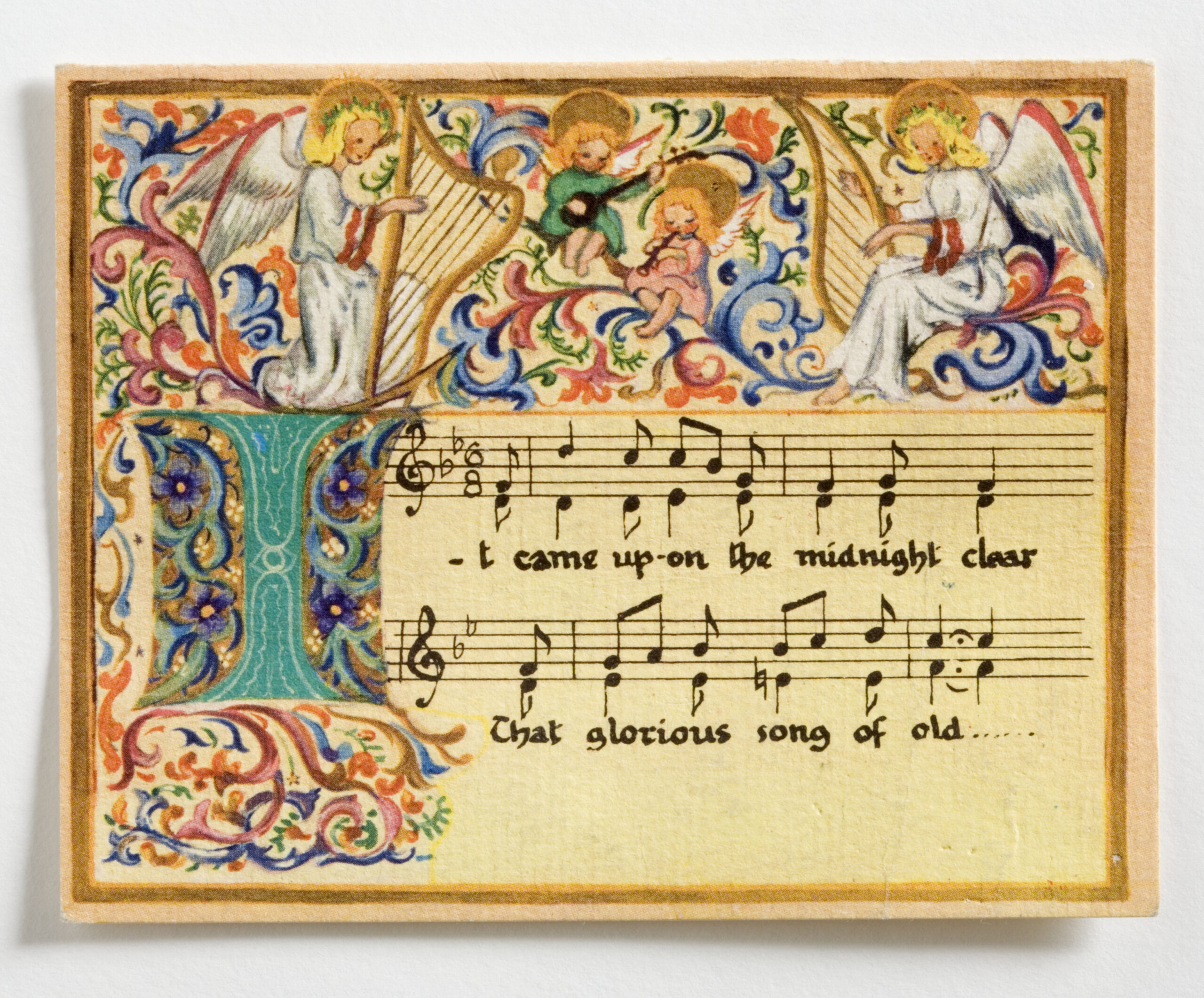 Christmas card hand-painted with a design of angels playing harps, musical staves, the illuminated letter 'I' in manuscript form and the words, 'It came upon the midnight clear/ That glorious song of old... ',