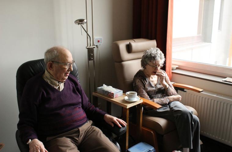Elderly couple sitting beside each other in hospital