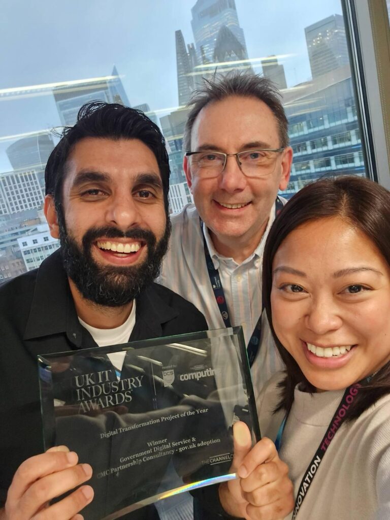 Three people smiling with the award