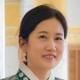 Headshot of exhibition curator wearing traditional white and green Korean clothing.