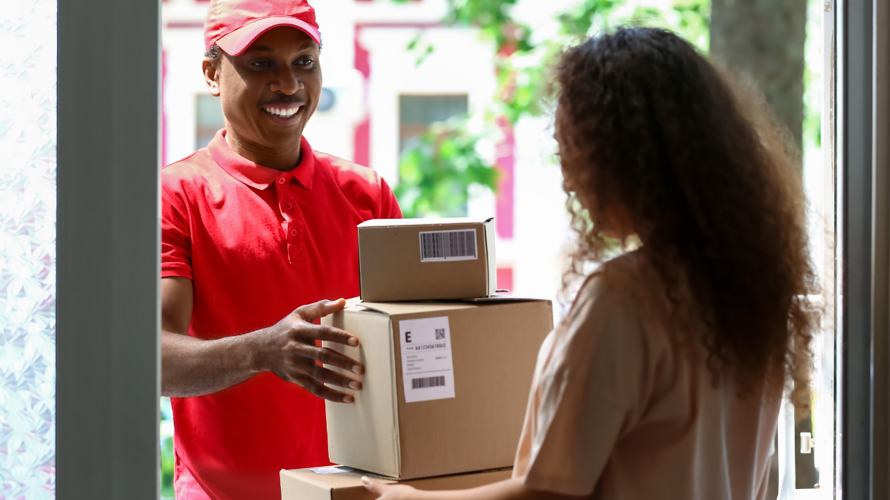 Delivery driver handing over a parcel to woman.