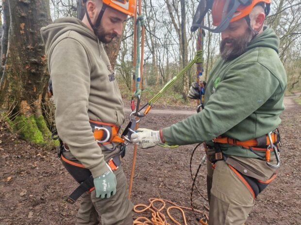 Mark checking a colleague's harness.