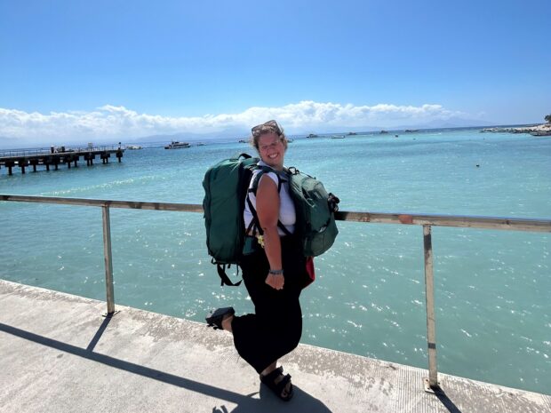 An image of Meg with her Osprey backpacks by the sea