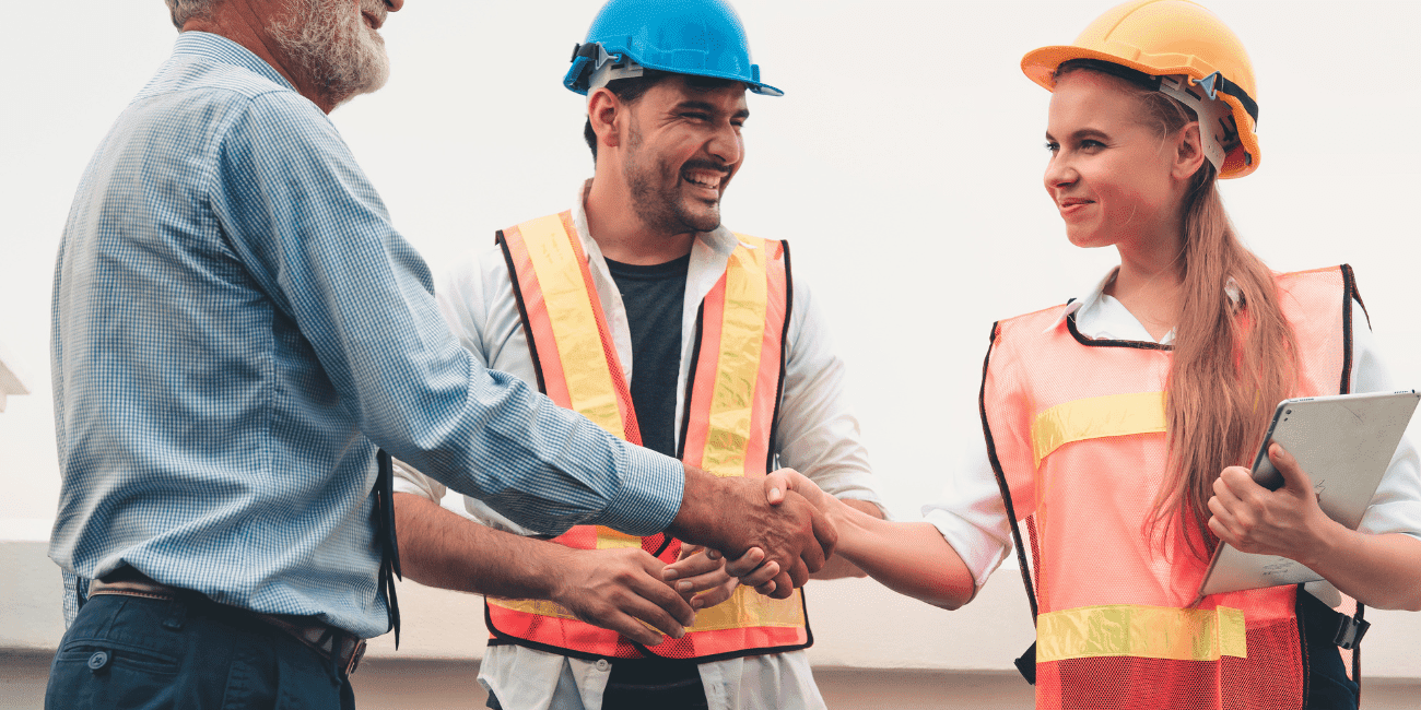 Woman With Tablet Shaking Hands With Man In Hard Hat