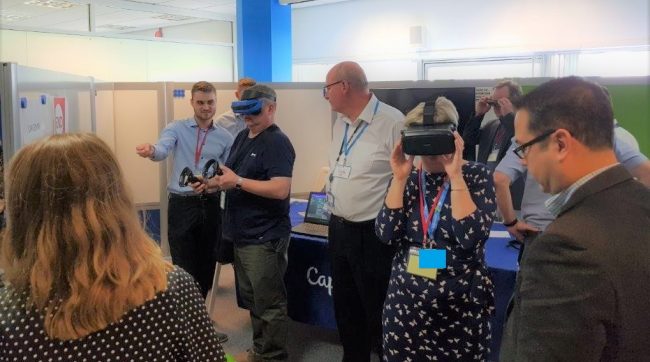 Severn people in a demonstration area. Two are wearing virtual reality masks