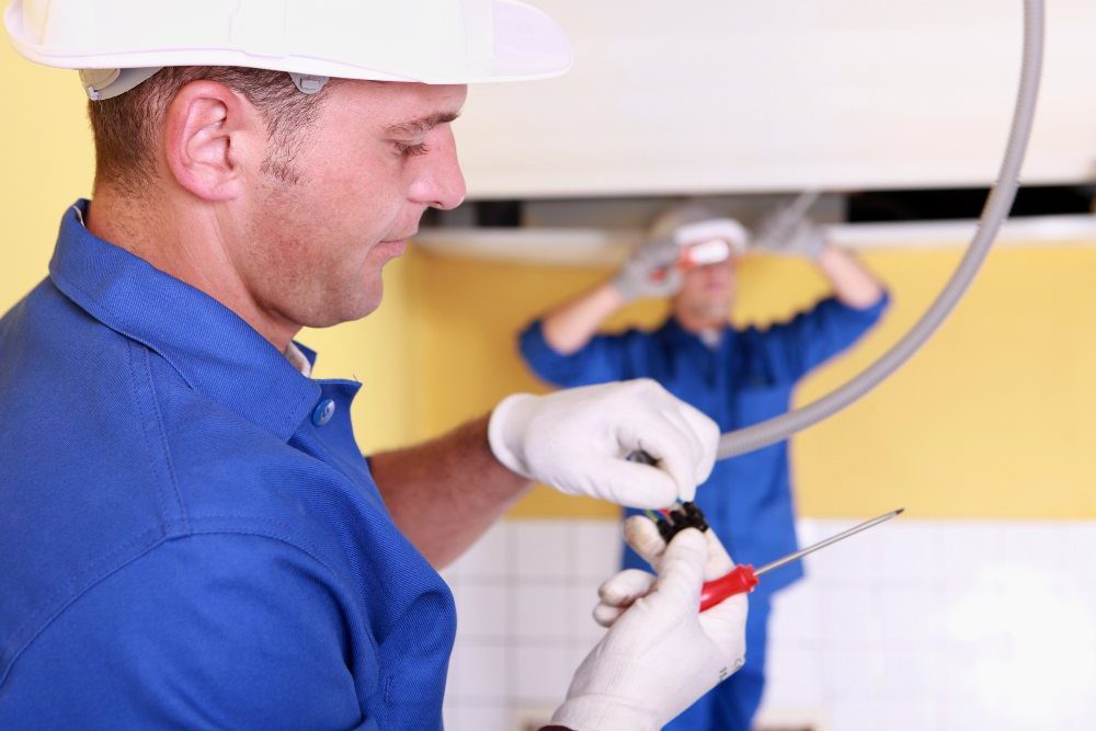 Main In White Gloves Working On An Electrical Cable
