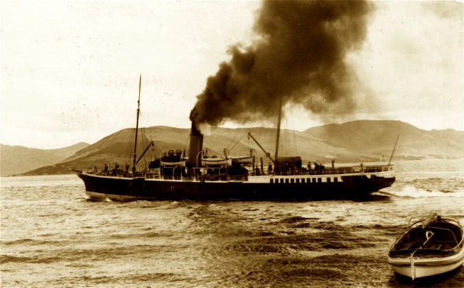 Historic sepia photograph of steamer with black smoke pouring out of its funnel, at sea with hills in the background, and a rowing boat at bottom right. 