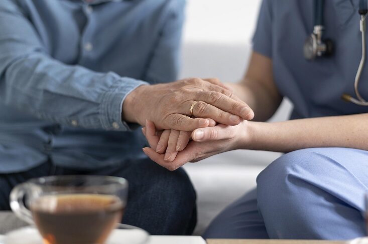 Mental health nurse holding patient's hand