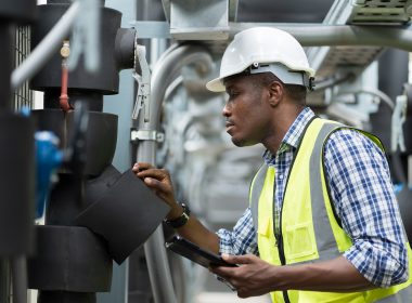 Male Plumber Engineer Worker Work With Digital Tablet In Sewer Pipes Area At Construction Site. African American Male Engineer Worker Check Or Maintenance Sewer Pipe Network System At Construction Sit