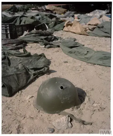 An abandoned helmet with a bullet hole lays on the ground. The last photo taken by conflict photojournalist and videographer Tim Hetherington on 20th April 2011