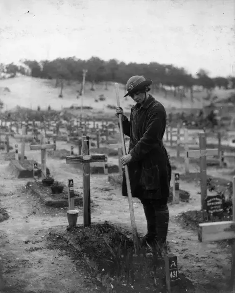 The grave of Betty Stevenson of the Young Men’s Christian Association (YMCA) tended by a member of the QMAAC at a graveyard in Étaples, France, 10 March 1919.
