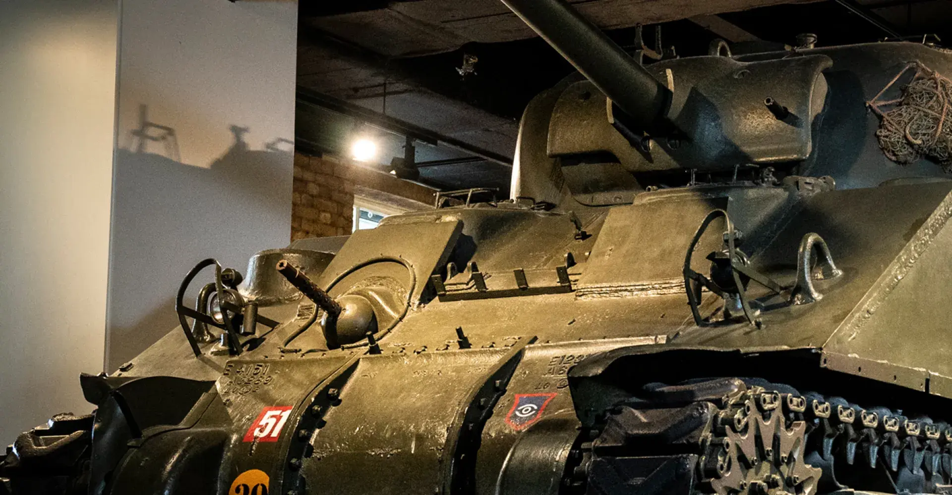 Visitors standing next to an armored vehicle in IWM London
