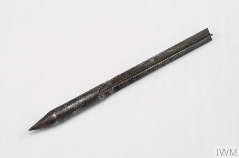 Metal flechette with a point at one end and an "X" cross-section along the shaft