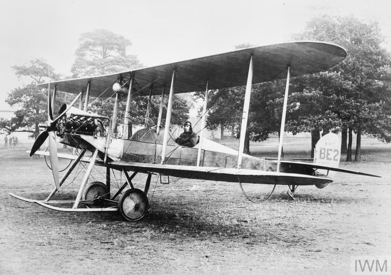 A B.E.2. biplane on the ground with a pilot sitting inside the cockpit