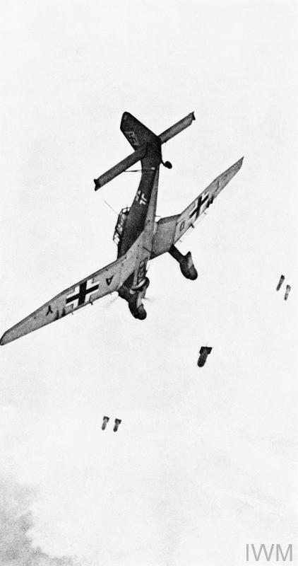 German aircraft with Iron Cross painted on its wings in vertical position against a cloud backdrop.