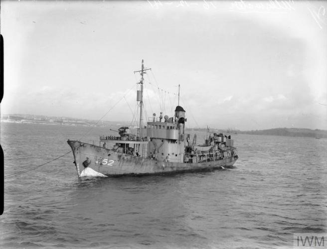 Trawler seen in port bow view, with her pennant number 252 in white to left, and land marking the horizon in the background.