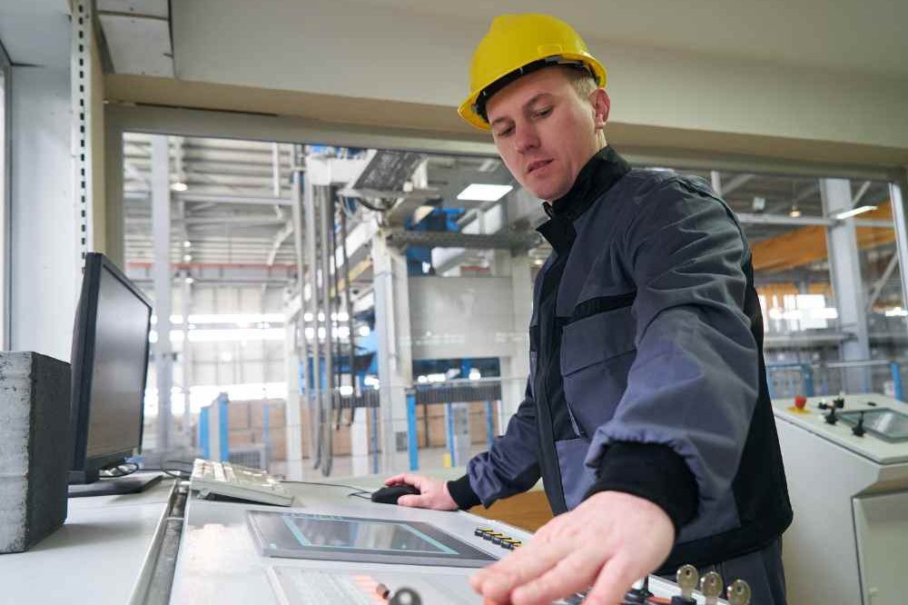Man In Yellow Hard Hat Working At Controls