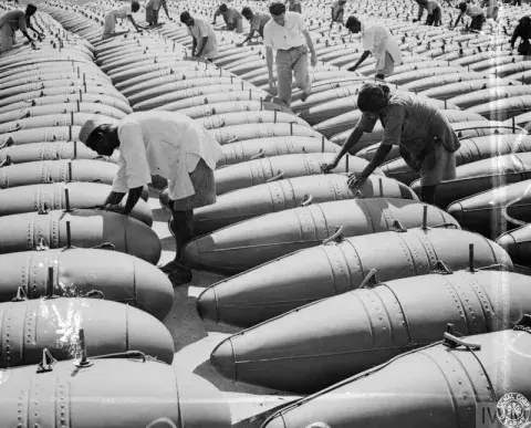 Workers at an aircraft factory in India are checking newly made fuel tanks lying on the ground