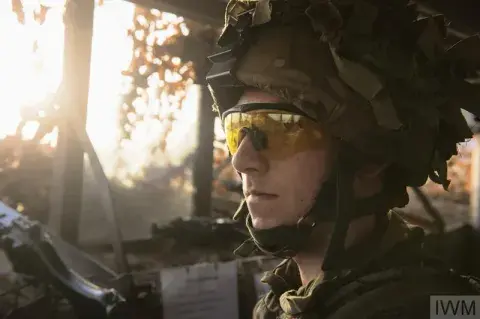 A soldier dressed in camouflage sits facing forwards. 