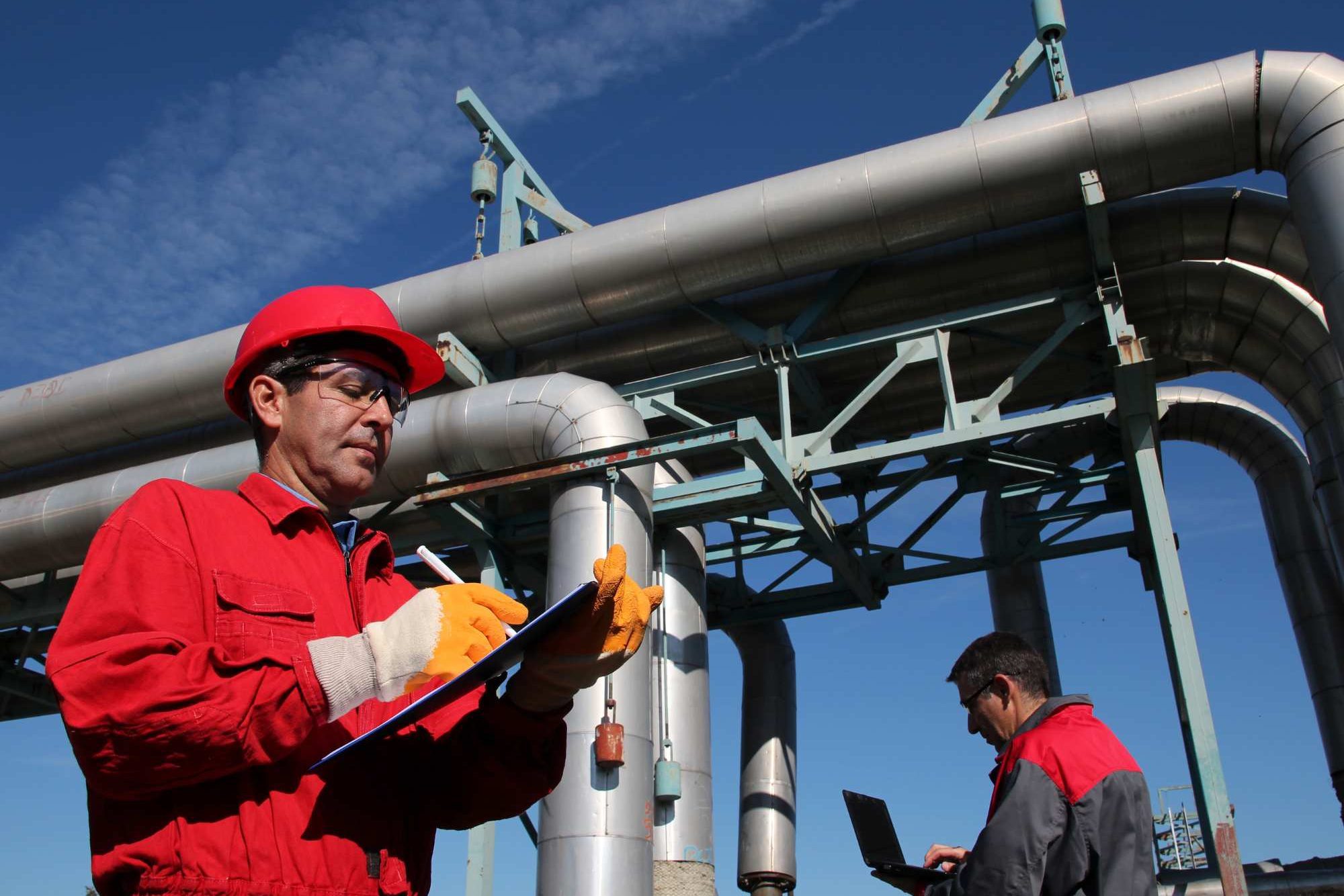 Two Men Inspecting Pipes On Site