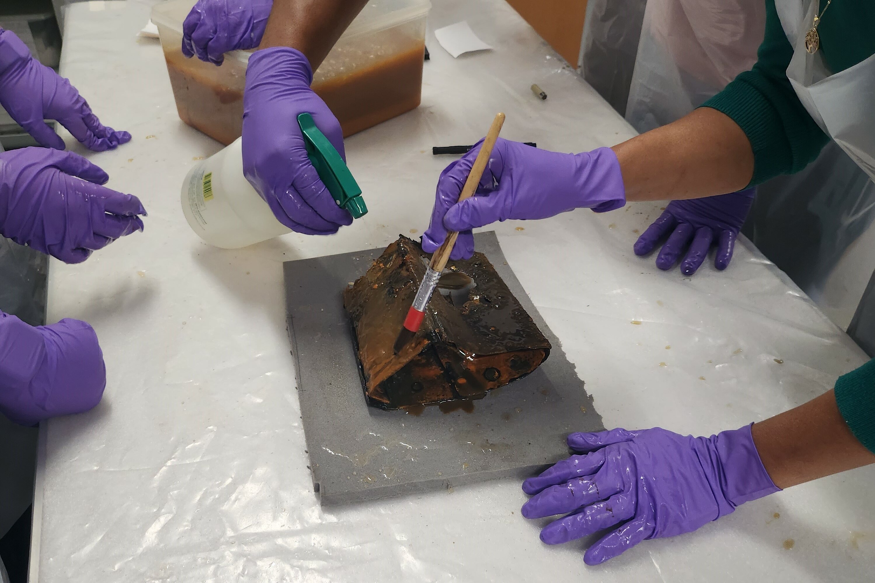 Delicately brushing an artefact at a museum restoration session