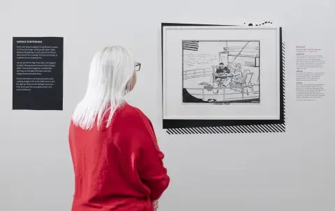 A visitor looks at an exhibit in 'Churchill in Cartoons: Satirising a Statesman'.