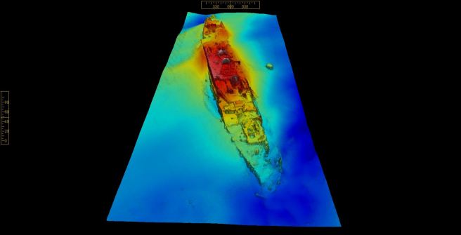 Three-dimensional colour image of wreck on the seabed, picked out in contrast colours modelling the wreck, with dark blue the seabed, light blue the lowest point and red showing the highest points of the wreck.