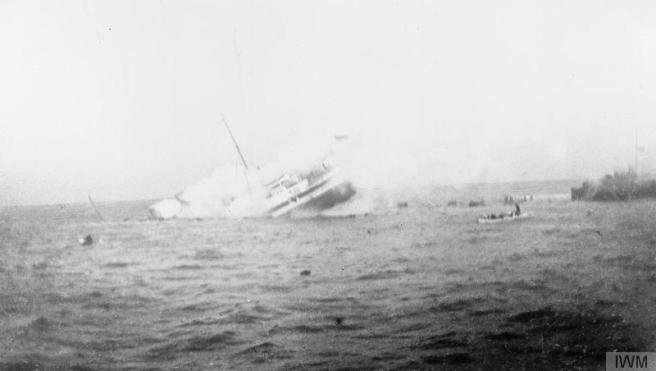 Black and white photograph of vessel sinking, throwing up spray, and resulting in visible sea turbulence.