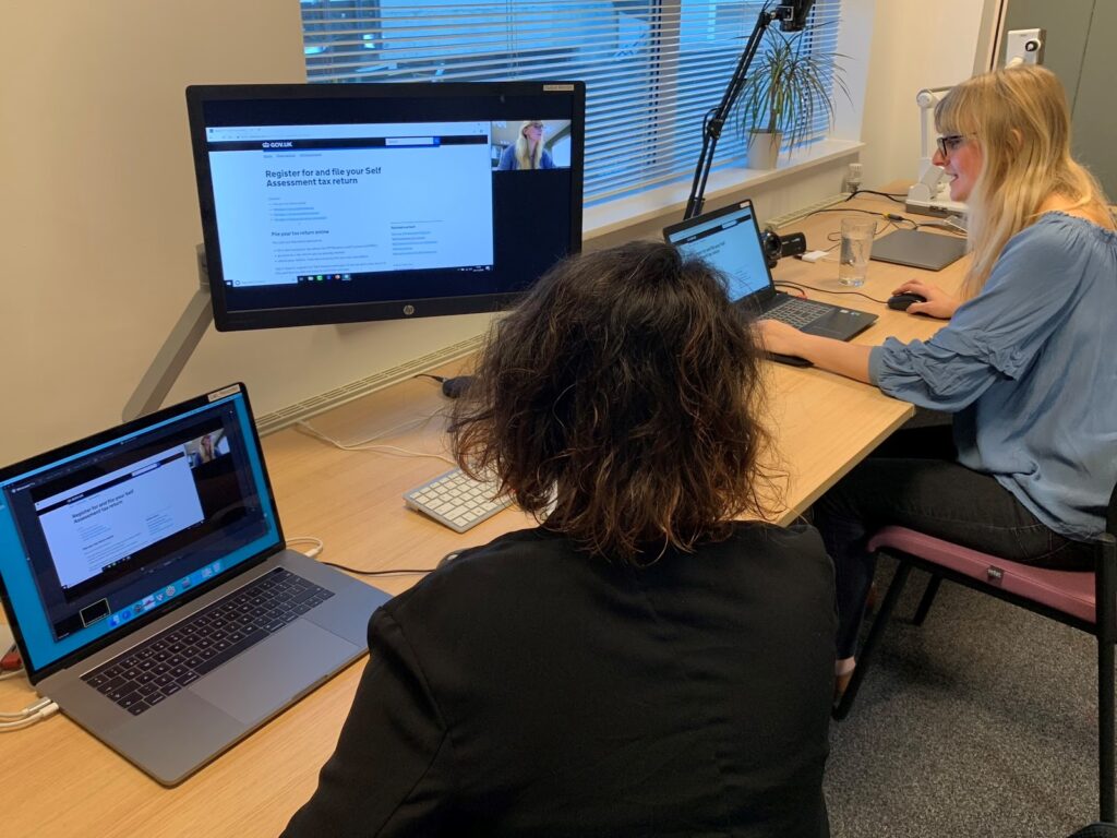 Two female user researchers sitting in front of laptops and screens in the user research lab