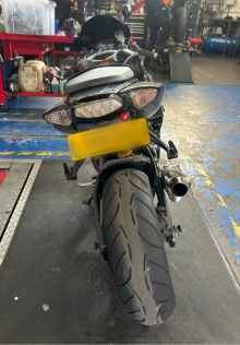 Photo of a motorbike in a garage during an MOT test