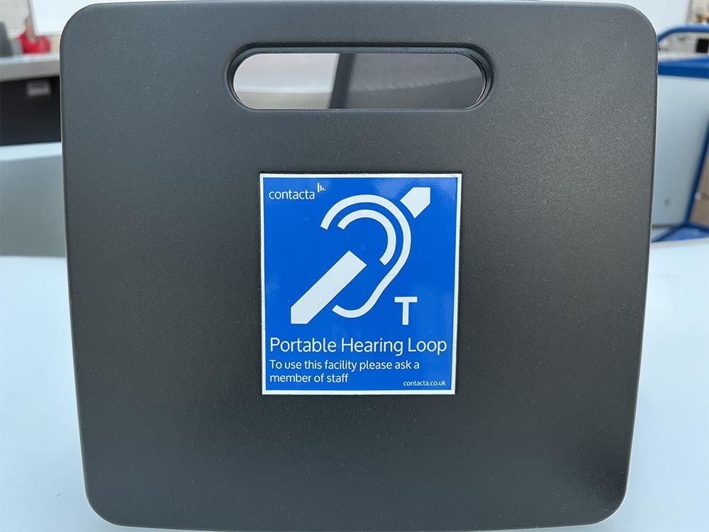 Grey box with blue sticker showing the induction loop icon.  