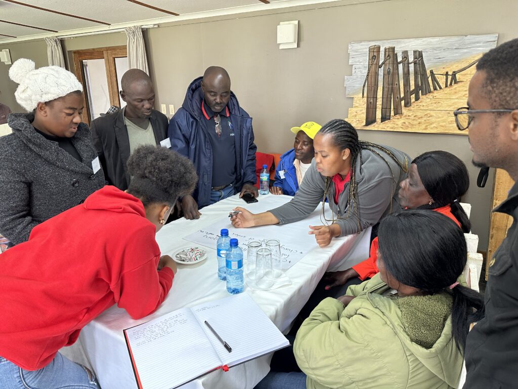 People round a table surrounded by paper
