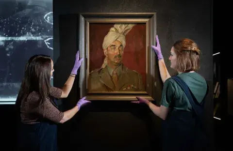 IWM staff preparing an artwork for display in the Second World War Galleries at IWM London