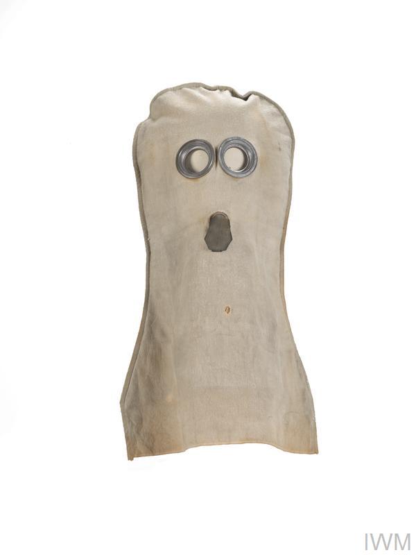 Anti gas helmet of hood style, made of grey flannel having two metal rimmed circualr glass eyepieces and a rubber mouthpiece.