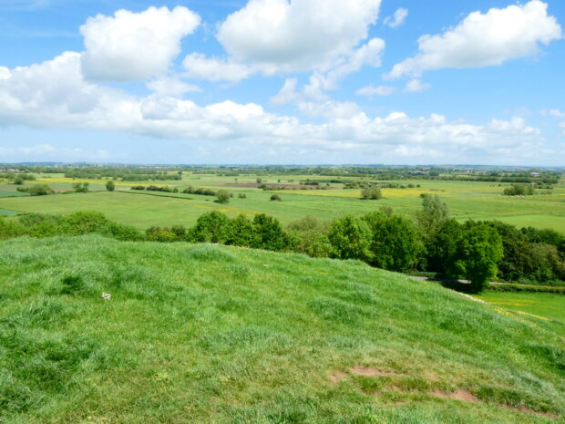 beautiful green rolling countryside with blue sky and white fluffy clouds