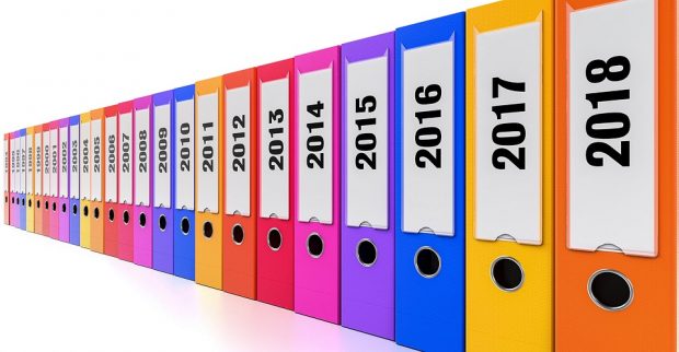 row of aligned ring binders, arranged chronologically by year back from 2018