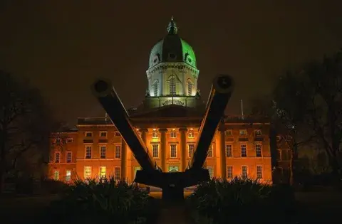 Night time external shot of IWM London lit up