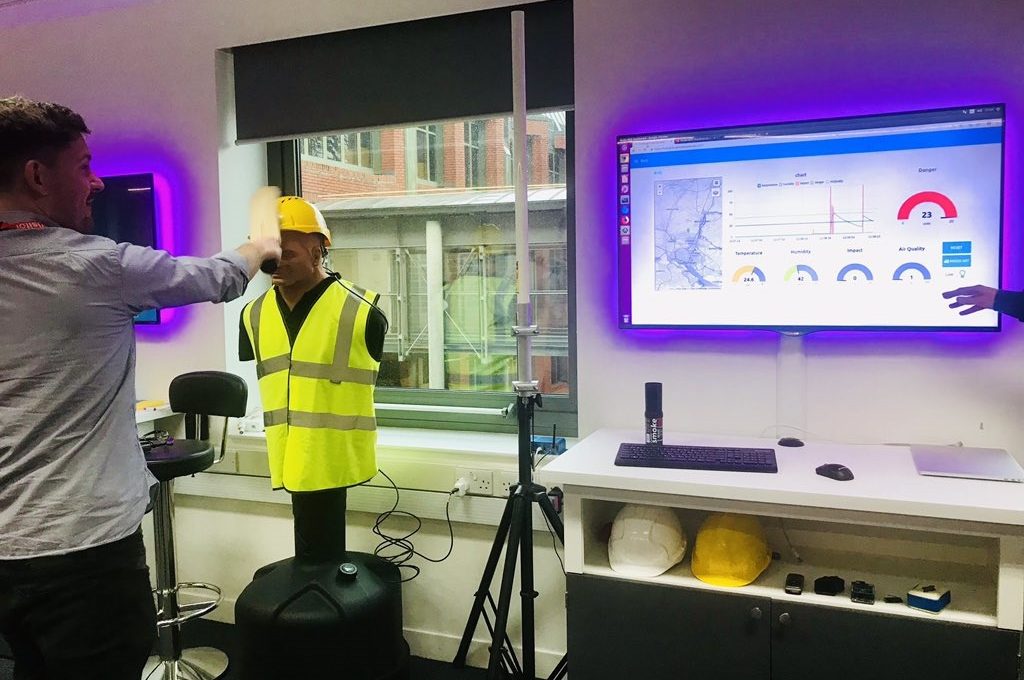 A male TechConnect participant trying out an IBM gadget in front of a large monitor