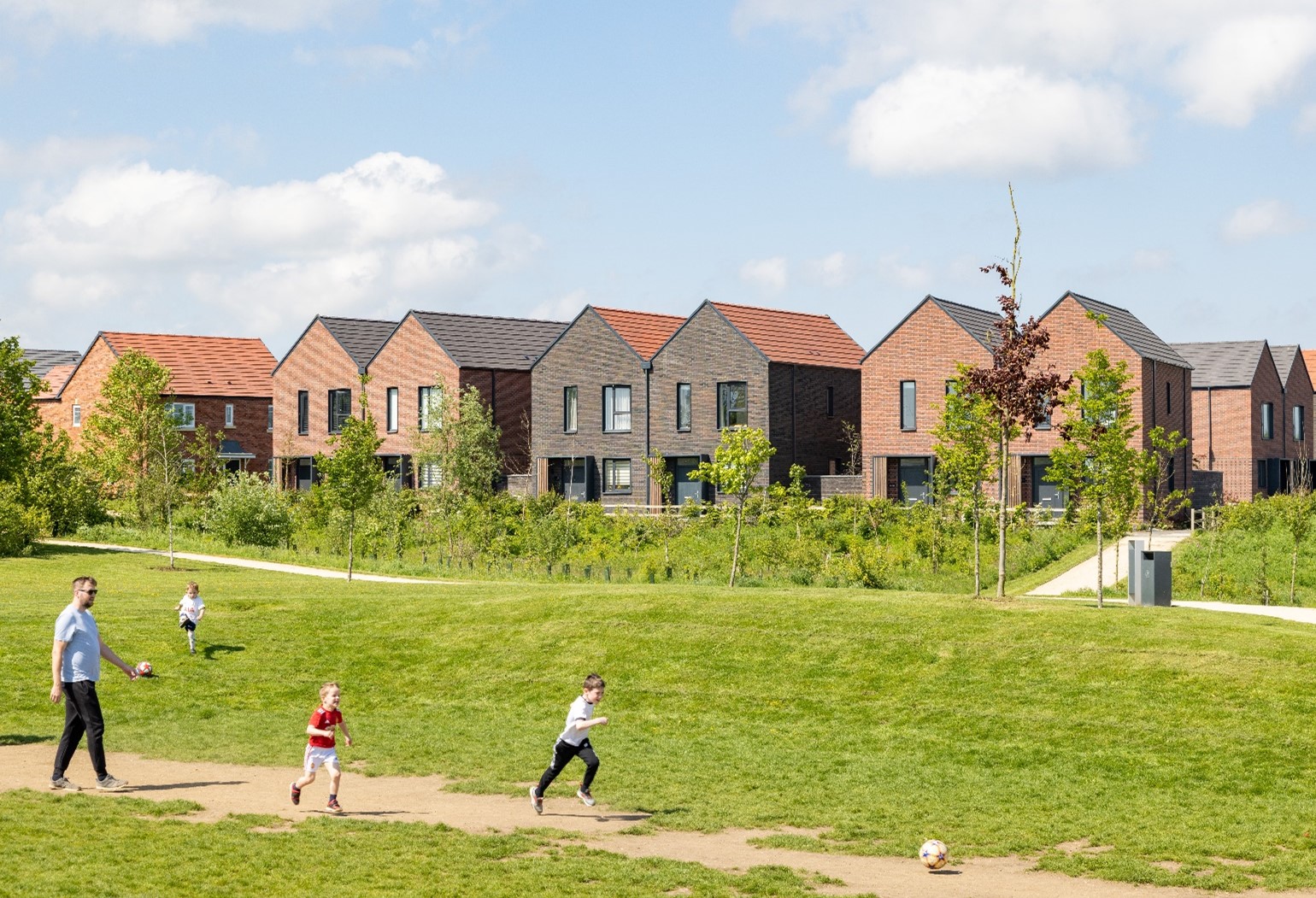 Image shows children playing in a green space at Houlton housing development, Rugby © JTP & Craig Auckland, Fotohaus