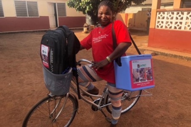 Image of a female riding a bike with two large bags