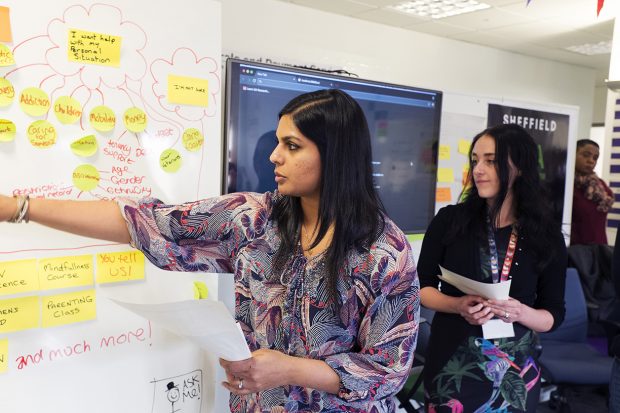 Two female colleagues collaborating in front of a whiteboard