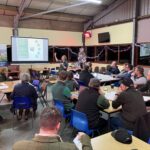 Farmers taking part in a workshop discussion in a community hall.