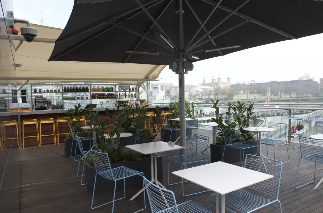 Tables and chairs arranged in front of a bar at HMS Belfast