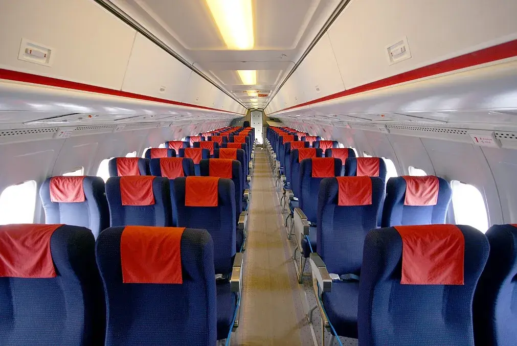 Interior shot of vintage BAC 1-11 airliner with blue seats and red head rests. 