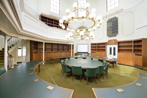 Domed 19th Century chapel with round green table and chairs and bookshelves 