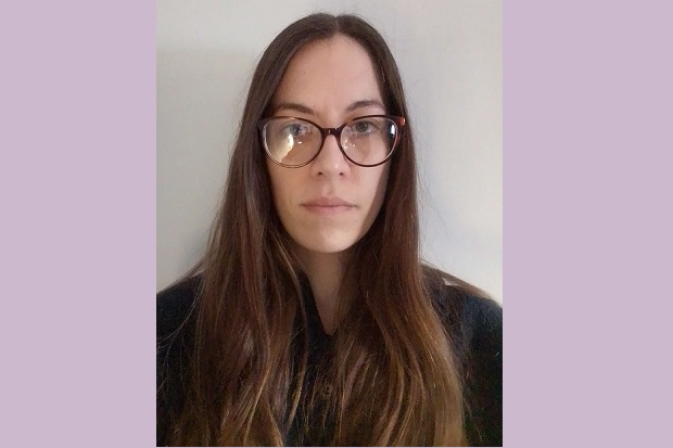 A lady with long hair, wearing glasses and a black top.