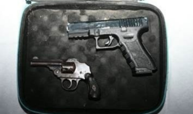 Two handguns – a Glock-style pistol and a revolver - in a black padded case
