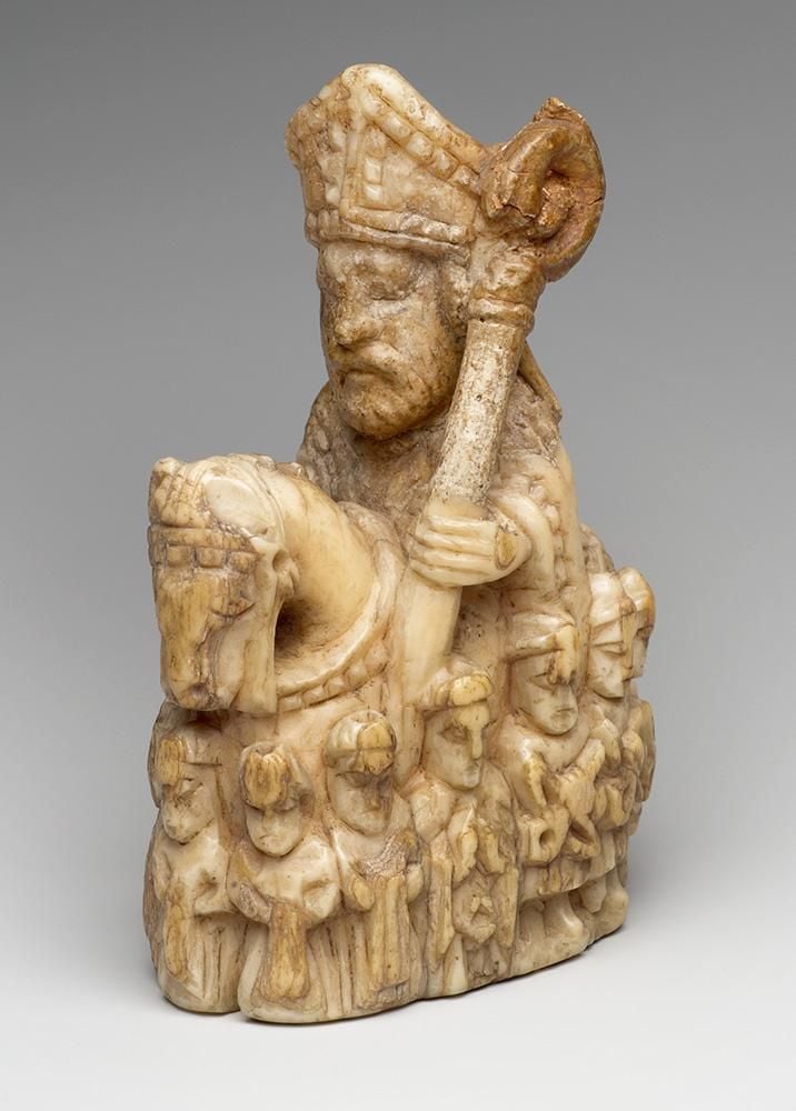 A chess piece in the shape of a bishop on horseback, surrounded by people