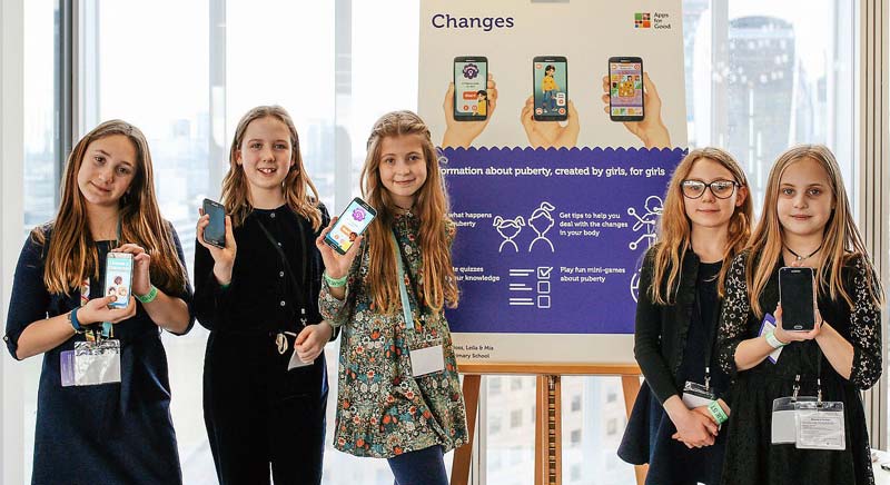 A group of 5 girl competitors showing mobile phones with their app on the screens