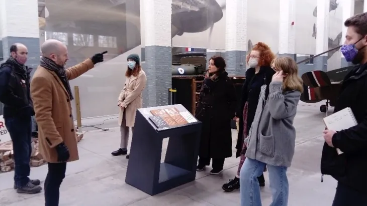 Curator Craig Murray stands in front of a group of people
